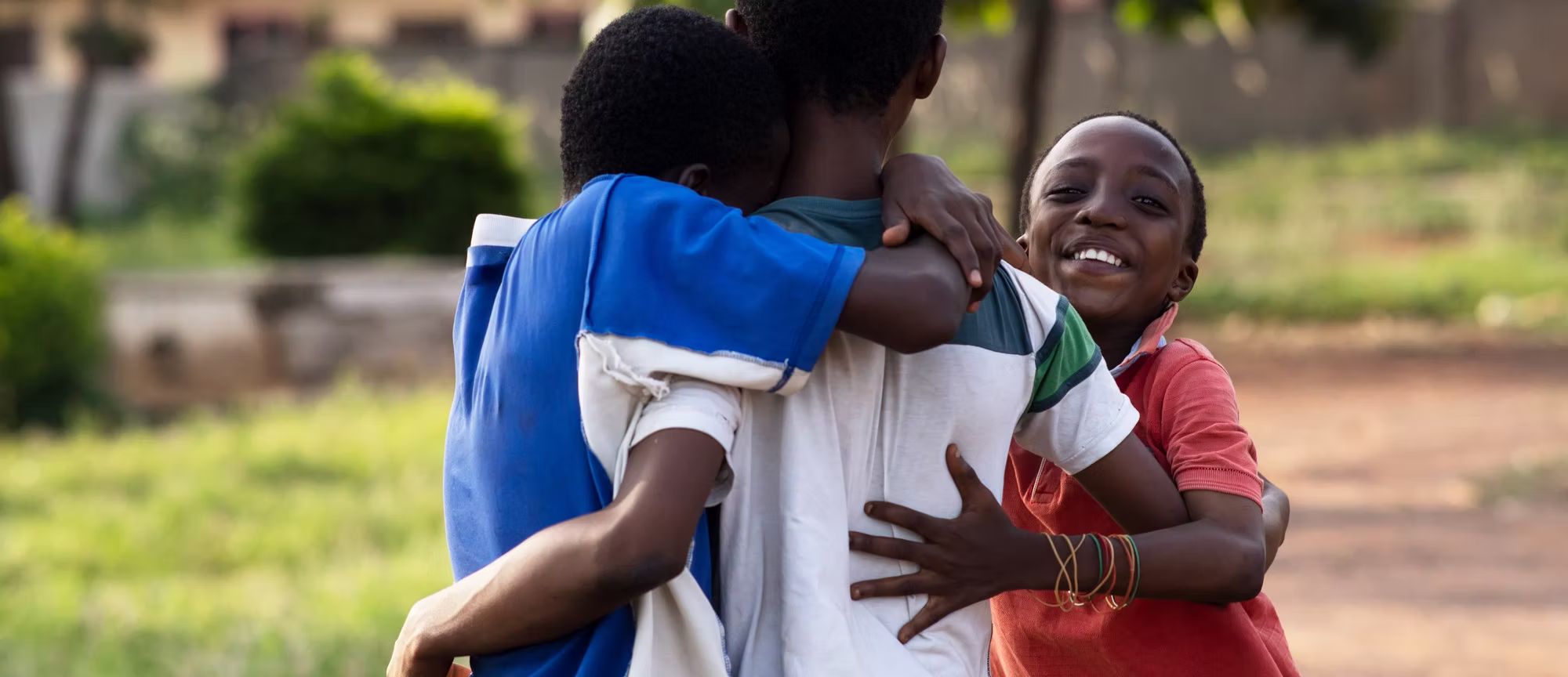 Three smiling children supported by BOKEF